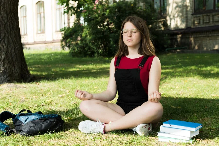 sideview-meditating-highschool-girl_23-2148225292